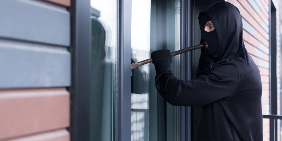 a burglar man tries to break the door lock and get into the apartment for robbery