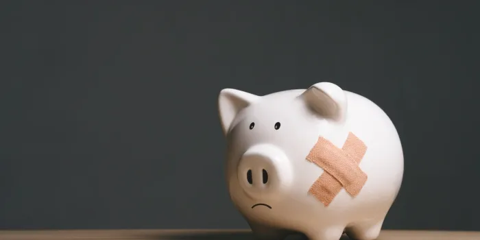 broken piggy bank with band aid bandage or plaster in finance background concept for economic recession, depression or bankruptcy