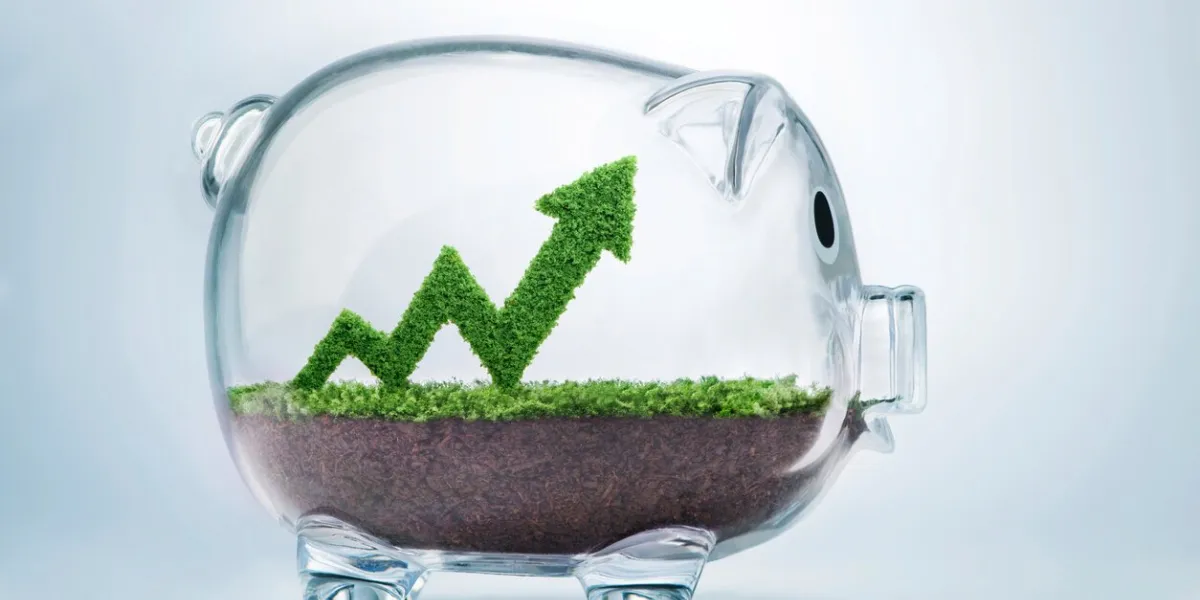 grass growing in the shape of an arrow graph, inside a transparent piggy bank, symbolising the care, dedication and investment needed for progress, success and profit in business