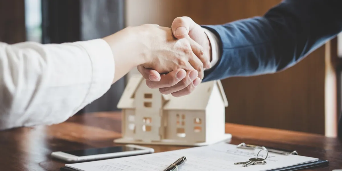 real estate agent and customers shaking hands together celebrating finished contract after about home insurance and investment loan, handshake and successful deal