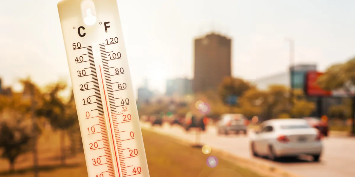 thermometer in front of cars and traffic during heatwave in montreal