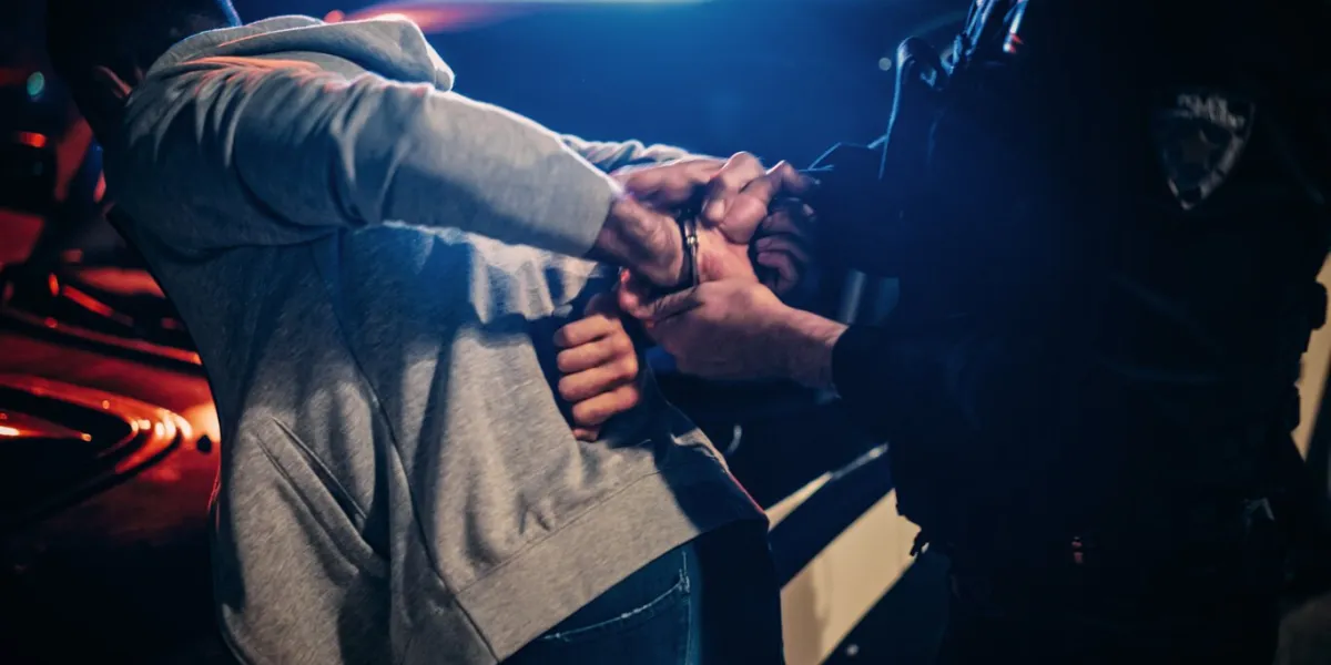 male policeman forcing a compliant civilian on the hood of police car officer violently pushing man against the car and handcuffing him shocking case of police brutality close up on hands