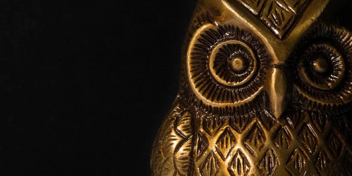 macro phot of a owl paper weight made of brass