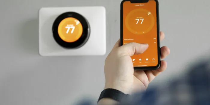 man uses a mobile phone with smart home app in modern living room
