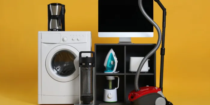 set of different home appliances with vacuum cleaner on yellow background