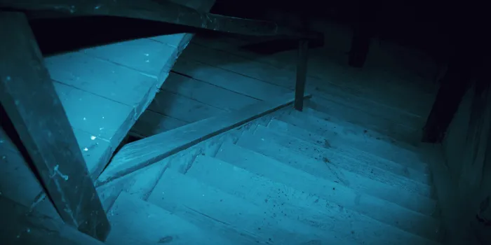 mystical horror scary garret background to halloween old antique dirty wooden staircase in the dark in a mysterious paranormal spooky basement or attic with black shadow in the blue light of the moon