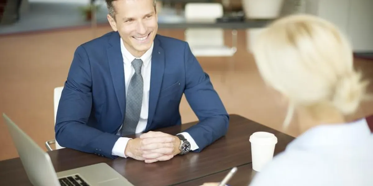 portrait de femme d'affaires de conseiller en investissement assis au bureau en face de l'ordinateur et de consultation avec l'homme professionnel exécutif