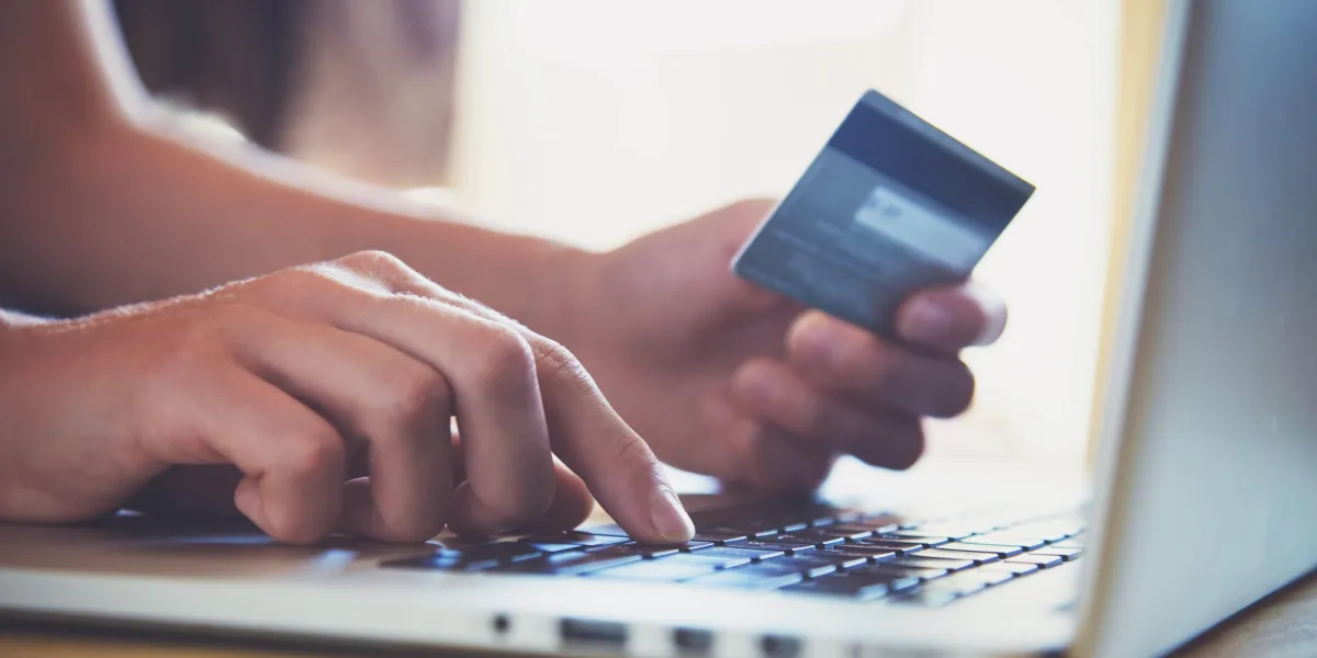 hands holding credit card and using laptop online shopping