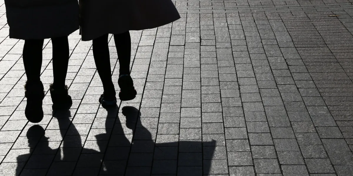female couple on a sidewalk, concept of female friendship, twins, dramatic life stories