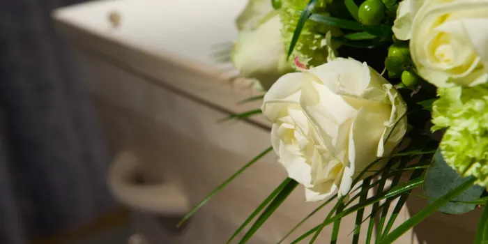a coffin with a flower arrangement in a morgue