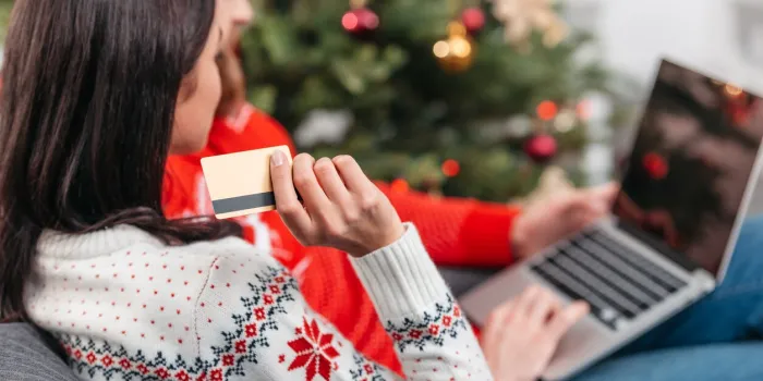 cropped of young couple shopping online with credit card and laptop at christmas