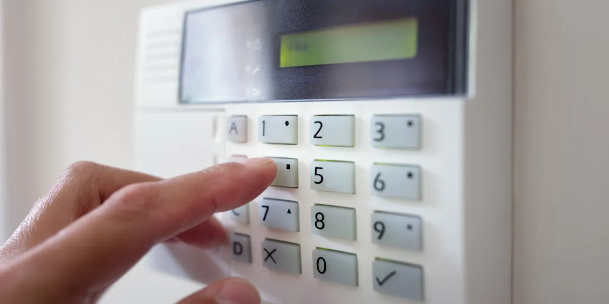 security alarm keypad with person arming the system concept for crime prevention