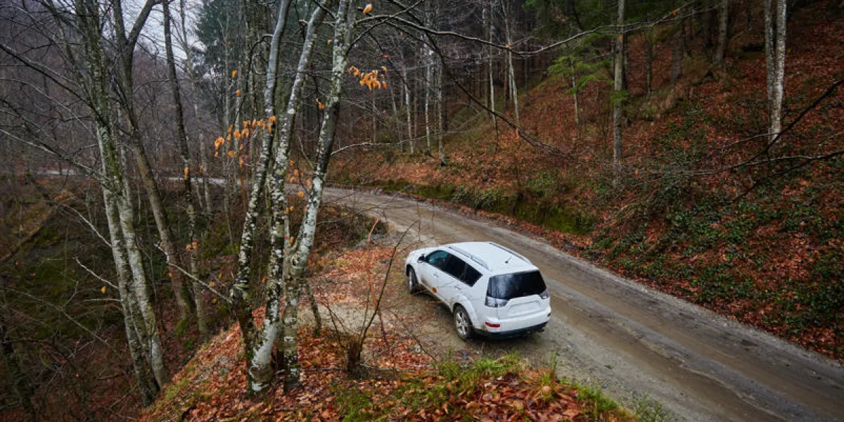 voiture suv blanche sur un sentier hors route dans un jour brumeux