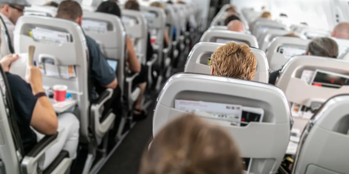 interior of commercial airplane with passengers in their seats during flight