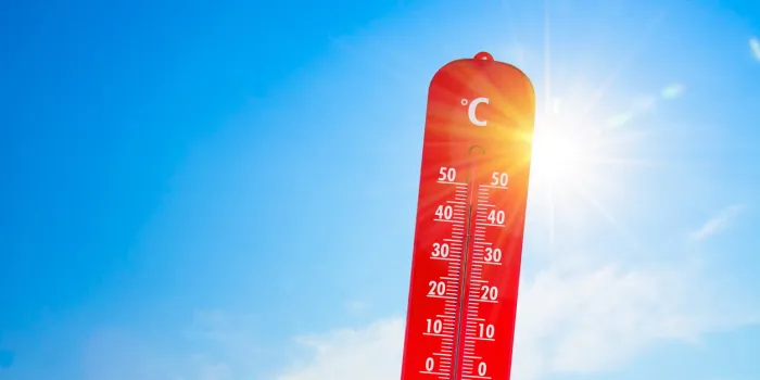 thermometer in front of the sun to represent global warming