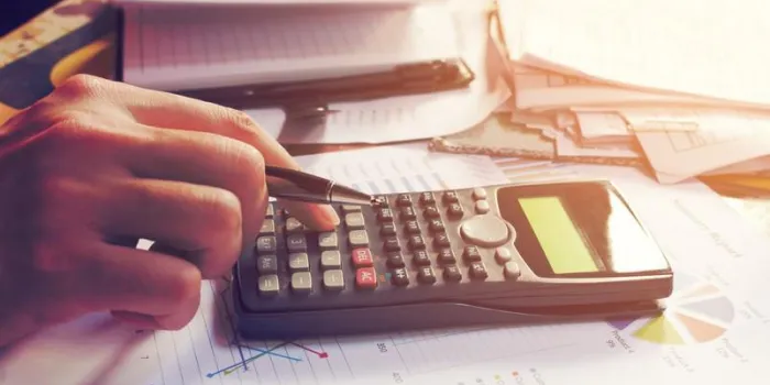 gros plan homme à l'aide de la calculatrice et faire de la finance dans le bureau à domicile