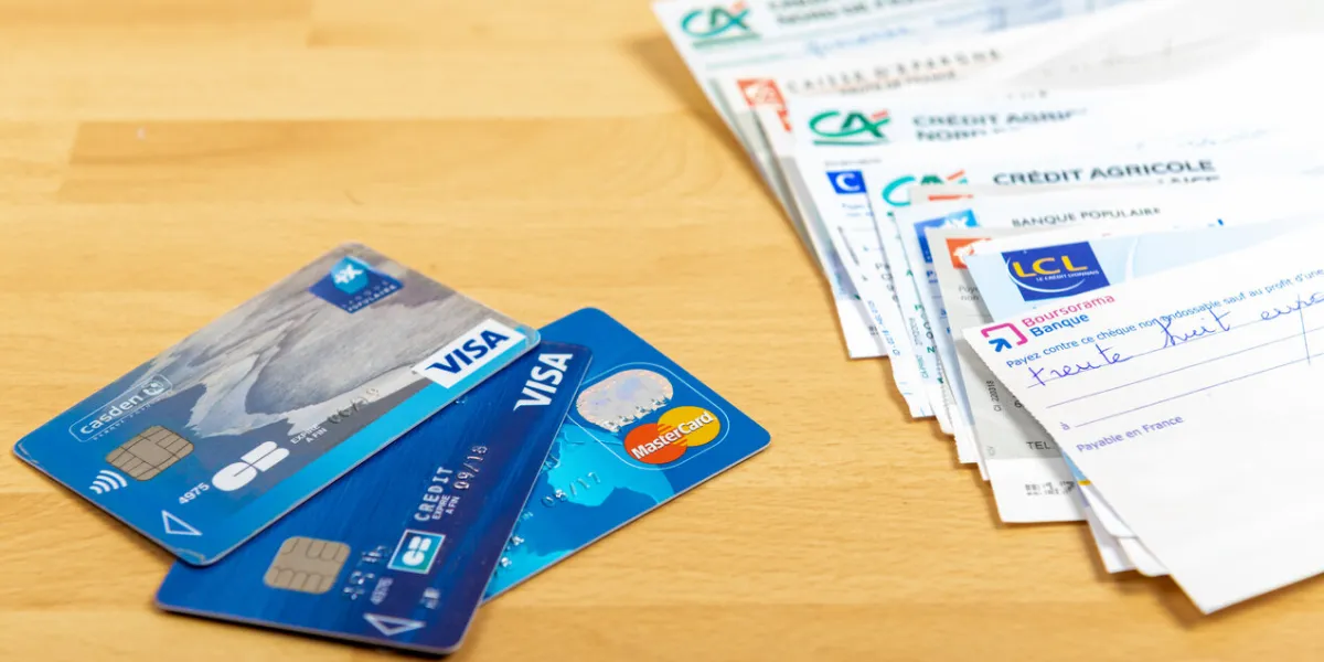 paris, france - november 18, 2019   checks of different french banks and credit cards set on a wooden desk france is the european country where checks are most used