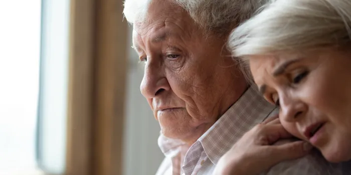 worried middle aged woman embracing upset old man from back, side view head shot close up portrait sensitive mature wife showing support, comforting depressed elder husband, experiencing grief