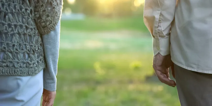 old couple looking into future, standing apart in park indifference and break-up