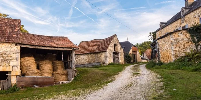 gravel road passing through old french farmhouses