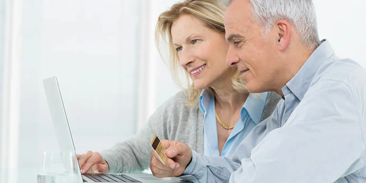 portrait of senior couple shopping online with credit card