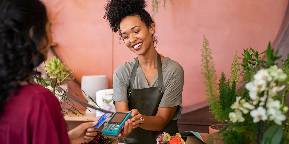 customer paying with contactless credit card at flower shop