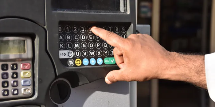 marseille, france - september 28, 2017   a man types the number of his car's license plate on the keyboard of a new parking meter