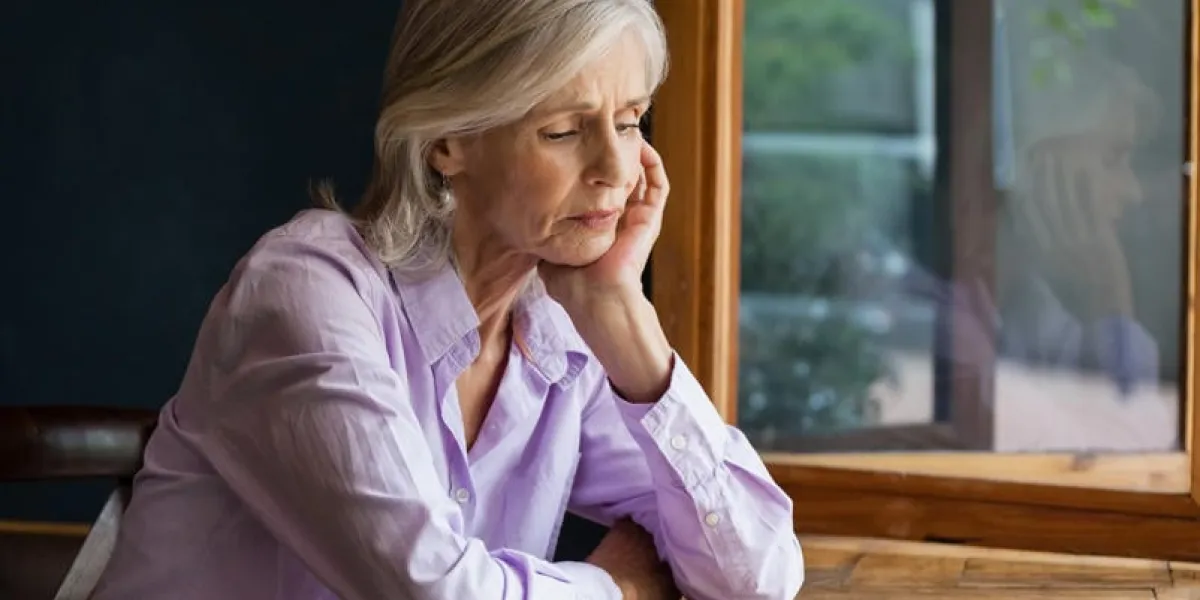 sad senior woman sitting at table in cafe shop
