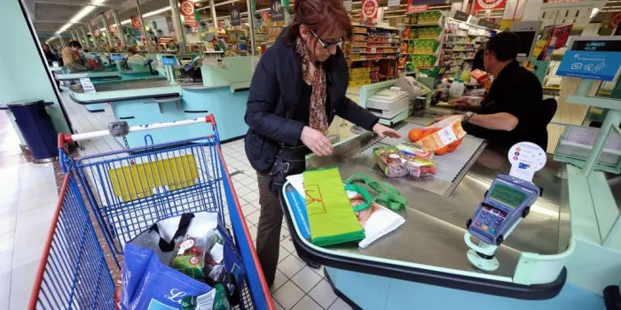 a woman puts her products in a trolley at a carrefour supermarket cashier on march 15, 2012 in the french northern city of hazebrouck afp photo   philippe huguen (photo by philippe huguen   afp)