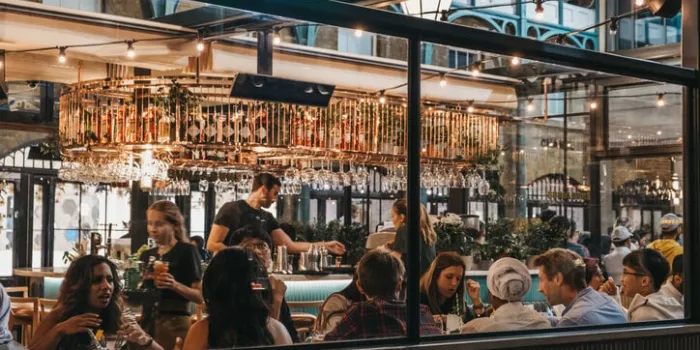 london, uk - august 31, 2019  view through the window of staff and customers inside buns and buns restaurant in covent garden market, one of the most popular tourist sites in london, uk