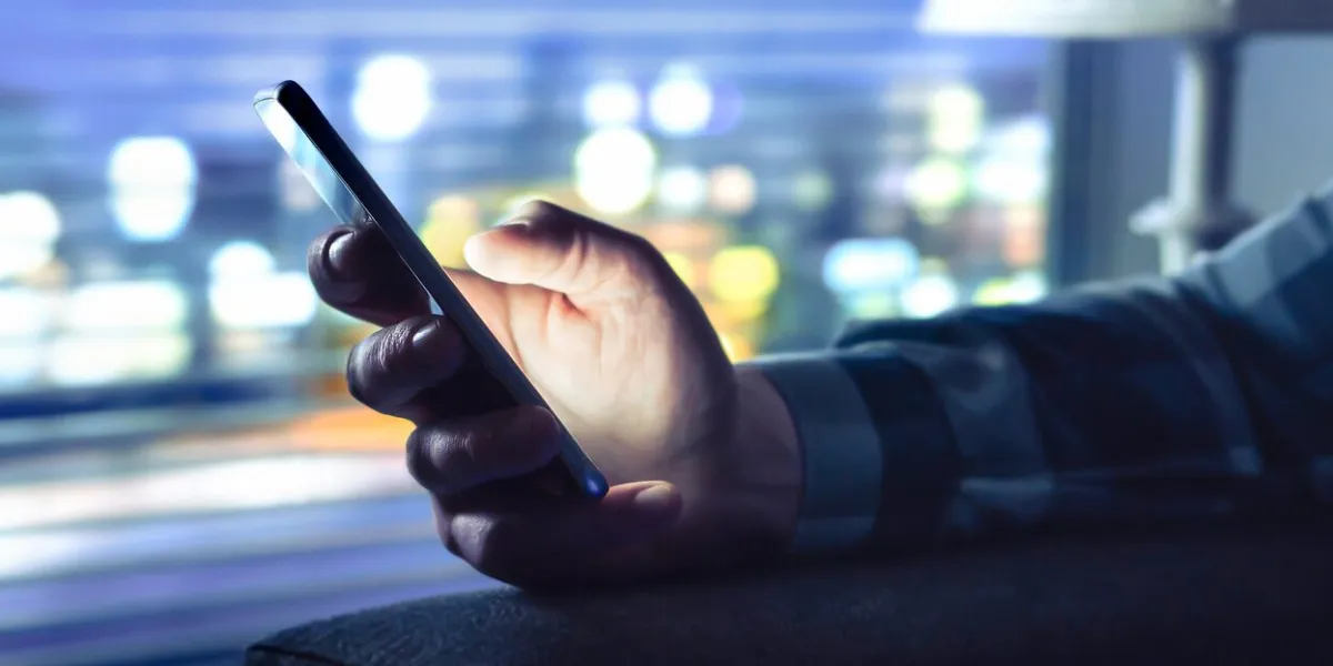 phone with fraud text message, unknown scam call or night texting man using smartphone anonymous caller or sms scammer cheater with secret dating light from cellphone screen in dark home