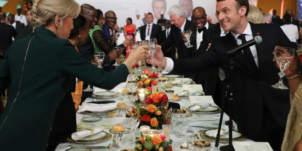 french president emmanuel macron (r) and his wife brigitte macron raise their glasses during a gala dinner at the sofitel abidjan hotel ivoire in abidjan on december 21, 2019, during a three day visit to west africa (photo by ludovic marin   afp)