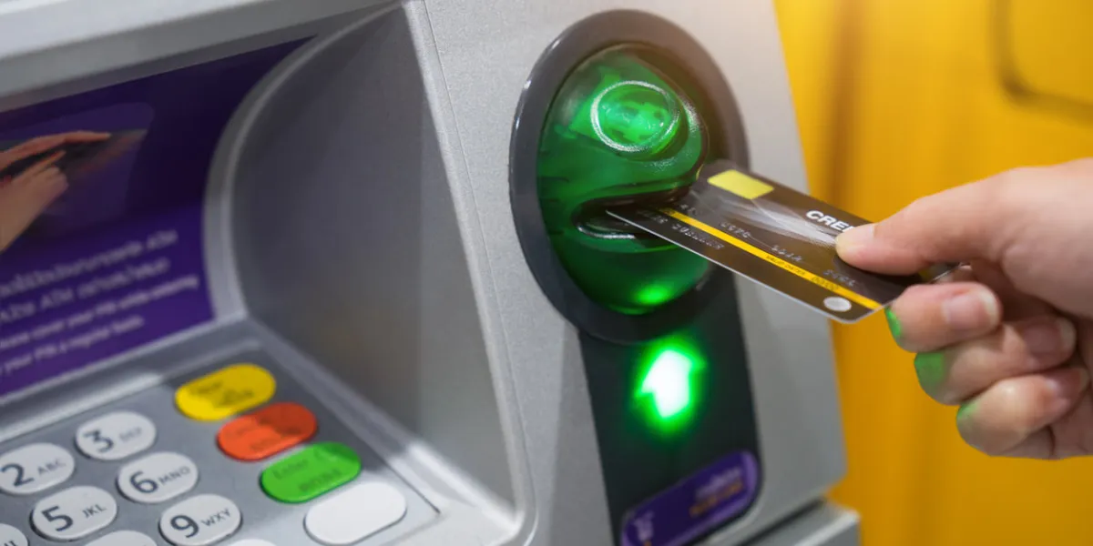 woman hand is inserting card to atm machine to withdraw or transfer money