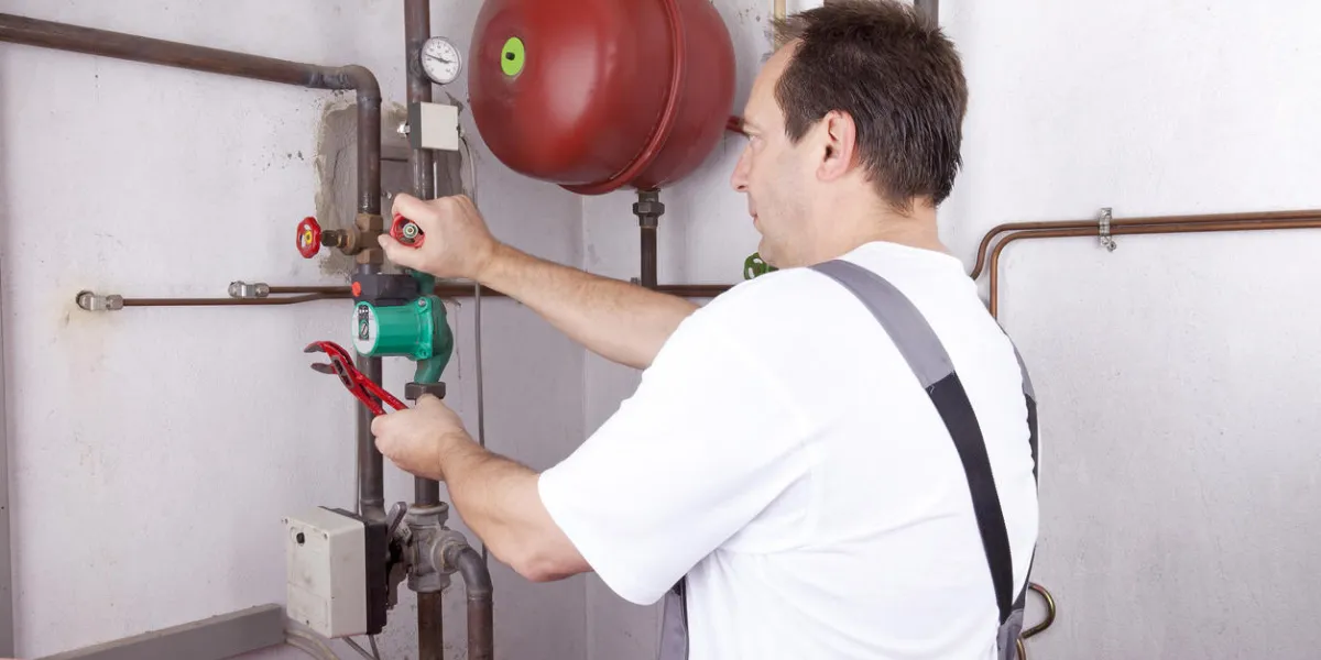 studio-shot of a heating engineer repairing and maintaining the heating system of a single-family house