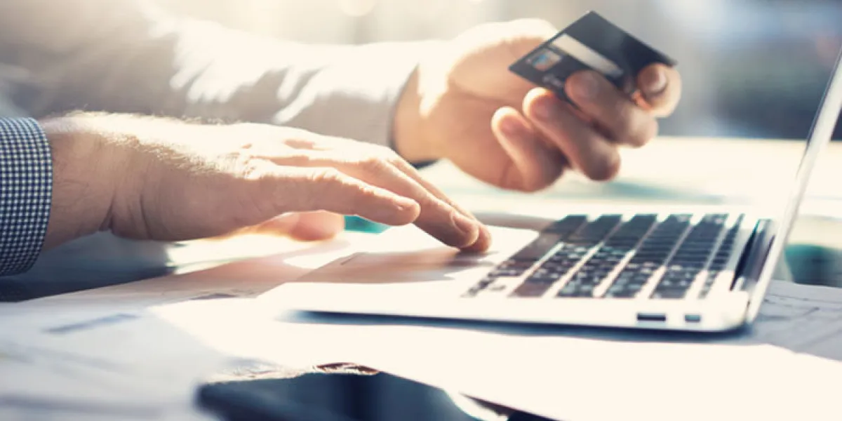 closeup businessman working with generic design notebook online payments, hands keyboard blurred background, film effect