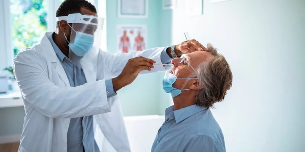 close up of a mature man having a nasal swab test done by his doctor