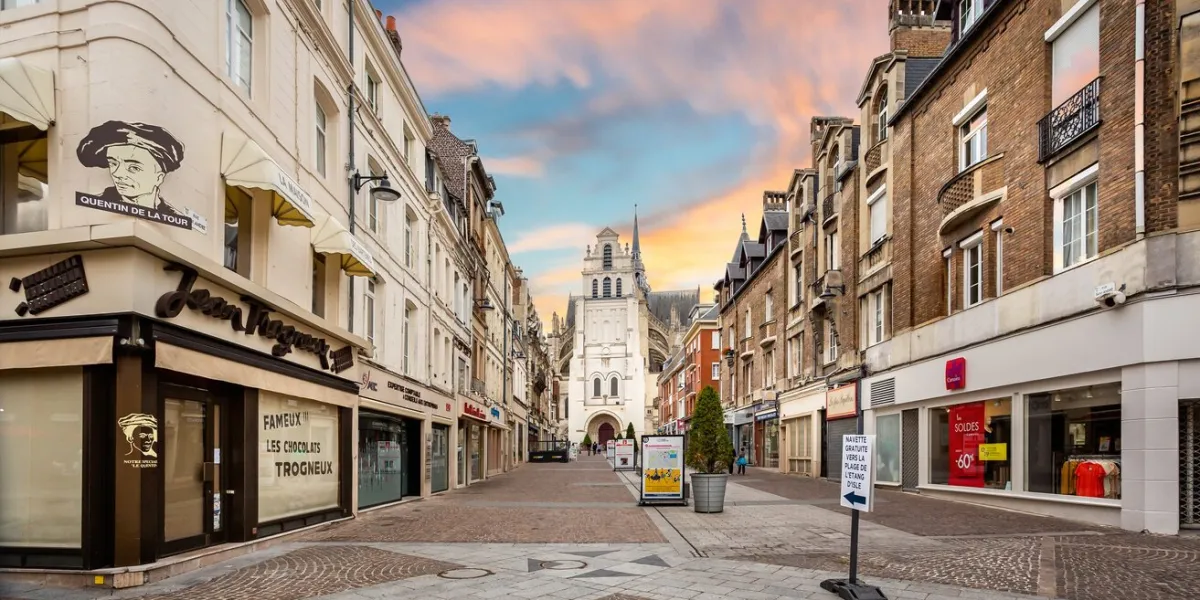shopping precinct leading to the basilica of saint quentin at sunset (church) in saint quentin, aisne, france on 7 july