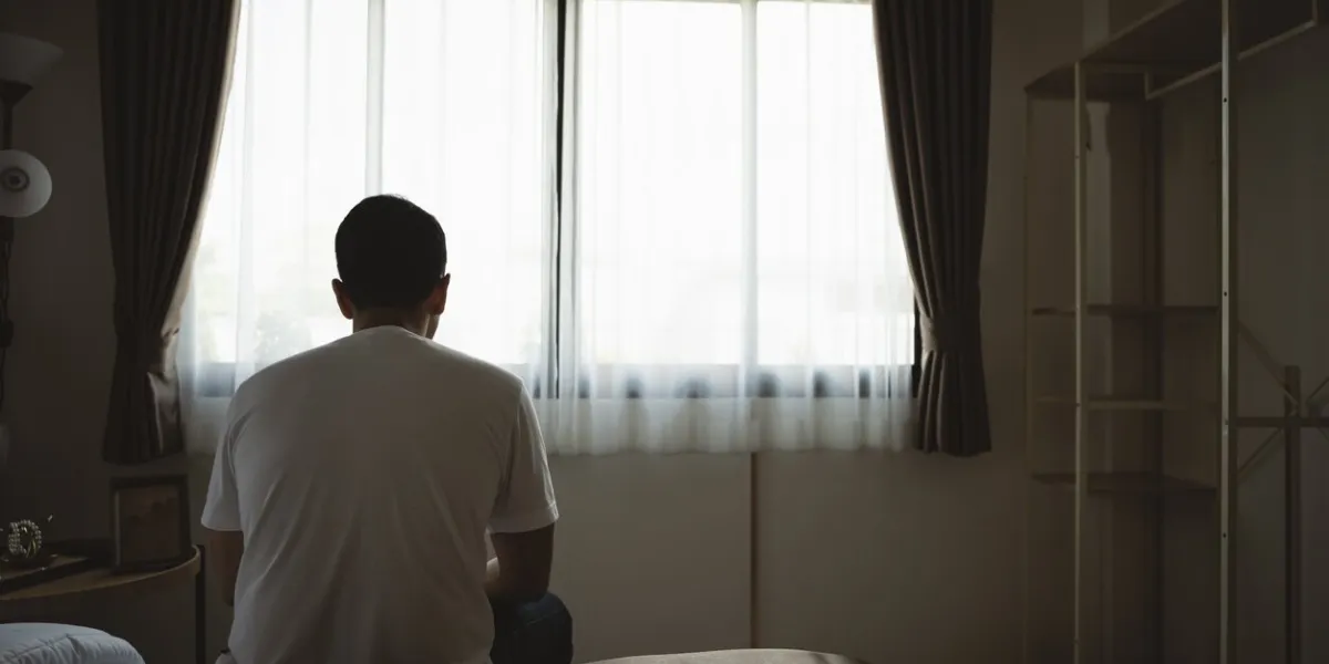 silhouette depressed man sadly sitting on the bed in the bedroom sad asian men suffering depression insomnia awake and sit alone on the bed in bedroom depression health people concept