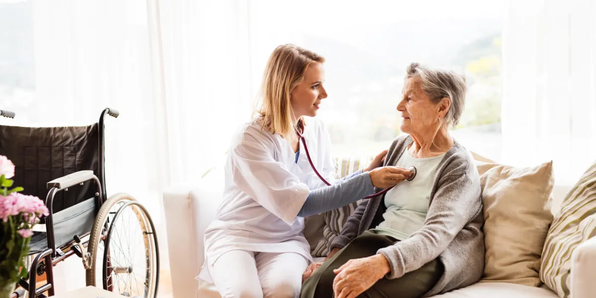 health visitor and a senior woman during home visit a nurse or a doctor examining a woman