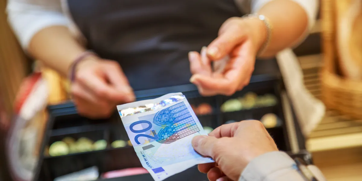 woman is paying in cash with euro banknotes