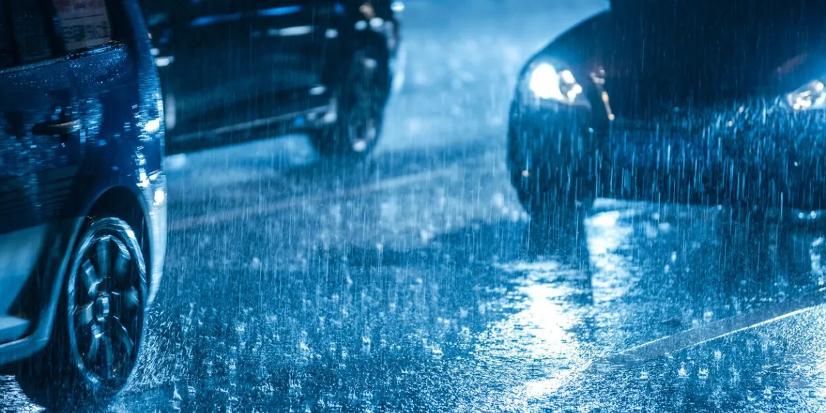 cars driving on wet road in the rain with headlights