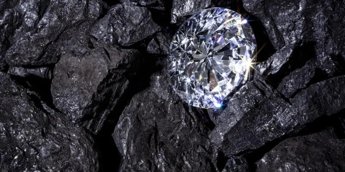 a single solitaire diamond in amongst some pieces of coal
