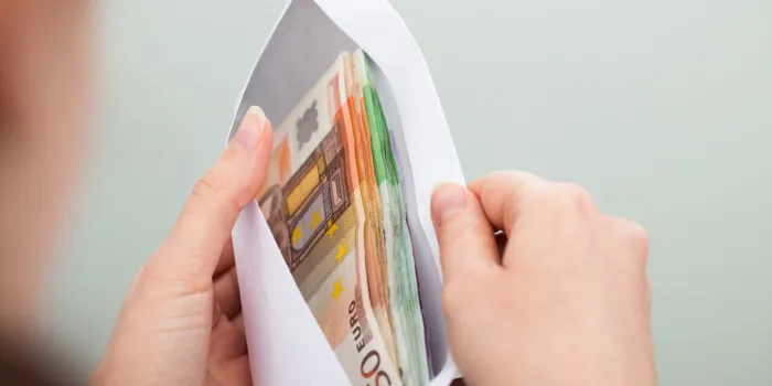 close-up of person checking out envelope with cash