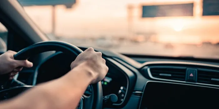 close-up - hand of man driving car on the road