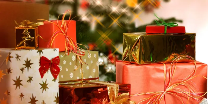 beaucoup de cadeaux de noël sur une table en arrière-plan un sapin de noël