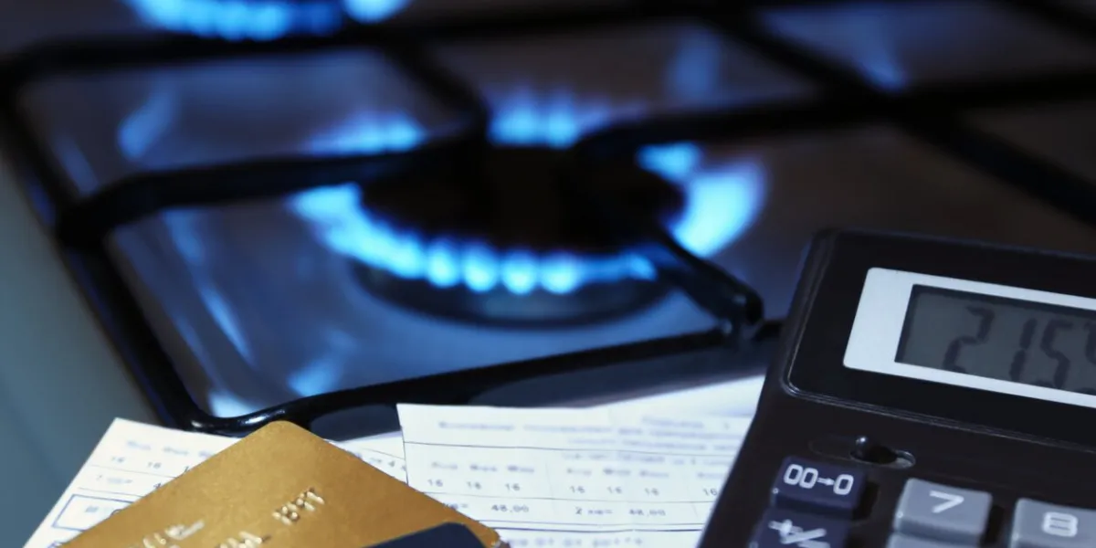 bank cards and a calculator on the background of a burning gas stove