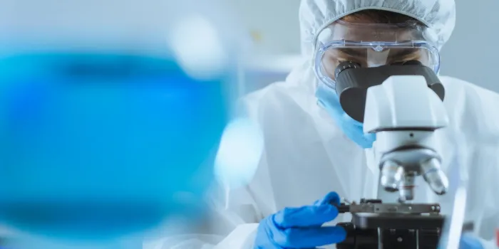 young asian handsome man scientist adjust focus and use microscope to looking biochemical cell in laboratory doctor and scientist work in laboratory pandemic of corona virus, covid19 concept