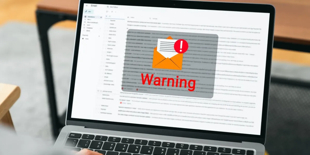 hand using laptop with shows a warning screen of new email notifications, hack password and personal data concept of cyber crime