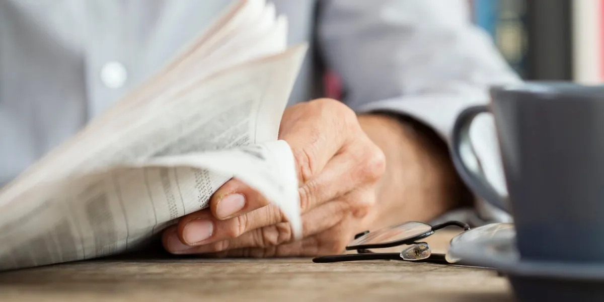 man newspaper reading on table