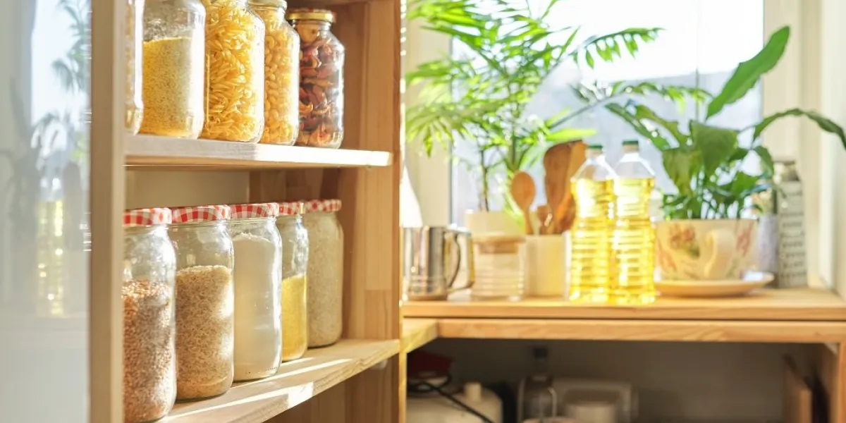 food storage at home, sunflower oil on table in pantry pantry interior, wooden shelf with food cans and kitchen utensils